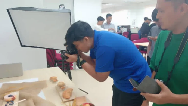 Participant working with camera equipment during photography training