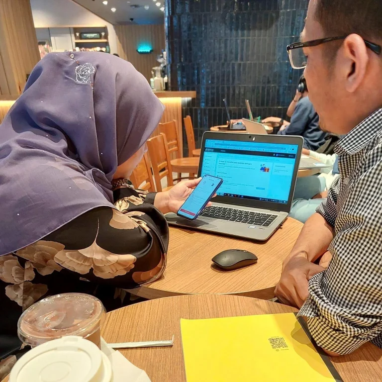 Coach Adi Zain guiding participants during a small-group digital workshop
